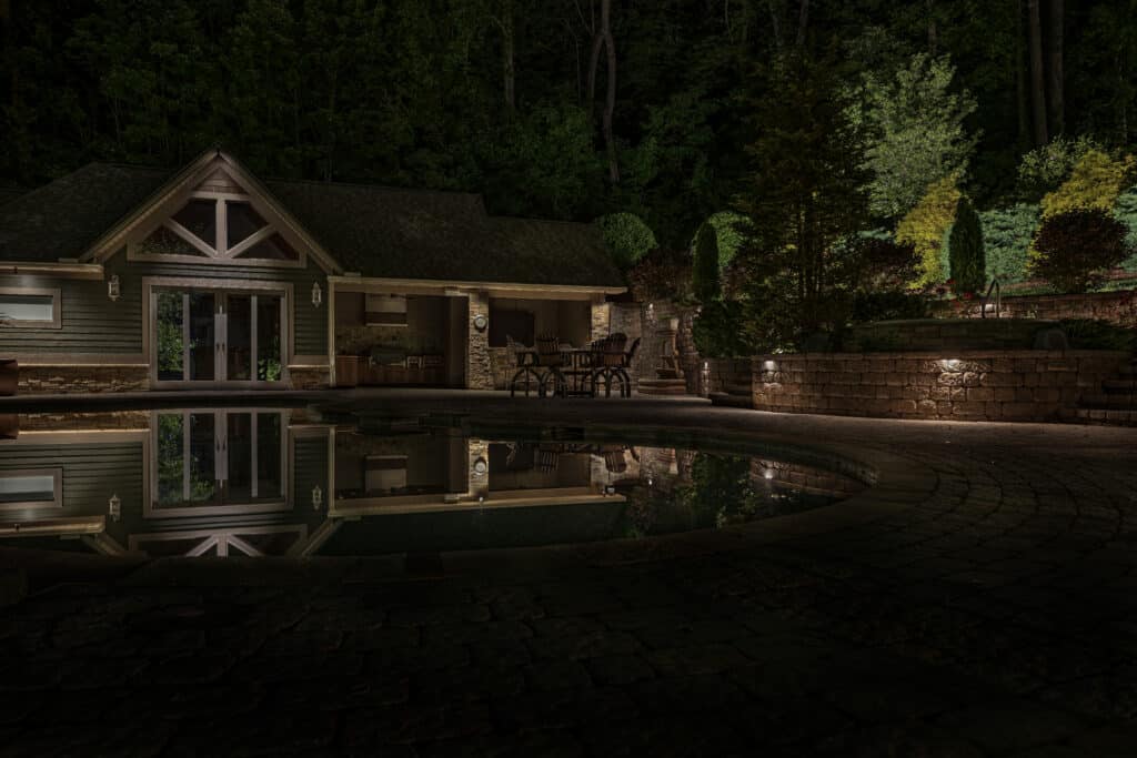 Outdoor lighting showcasing illuminating a backyard pool while planning a new landscape that helps enhance functionality and beauty.